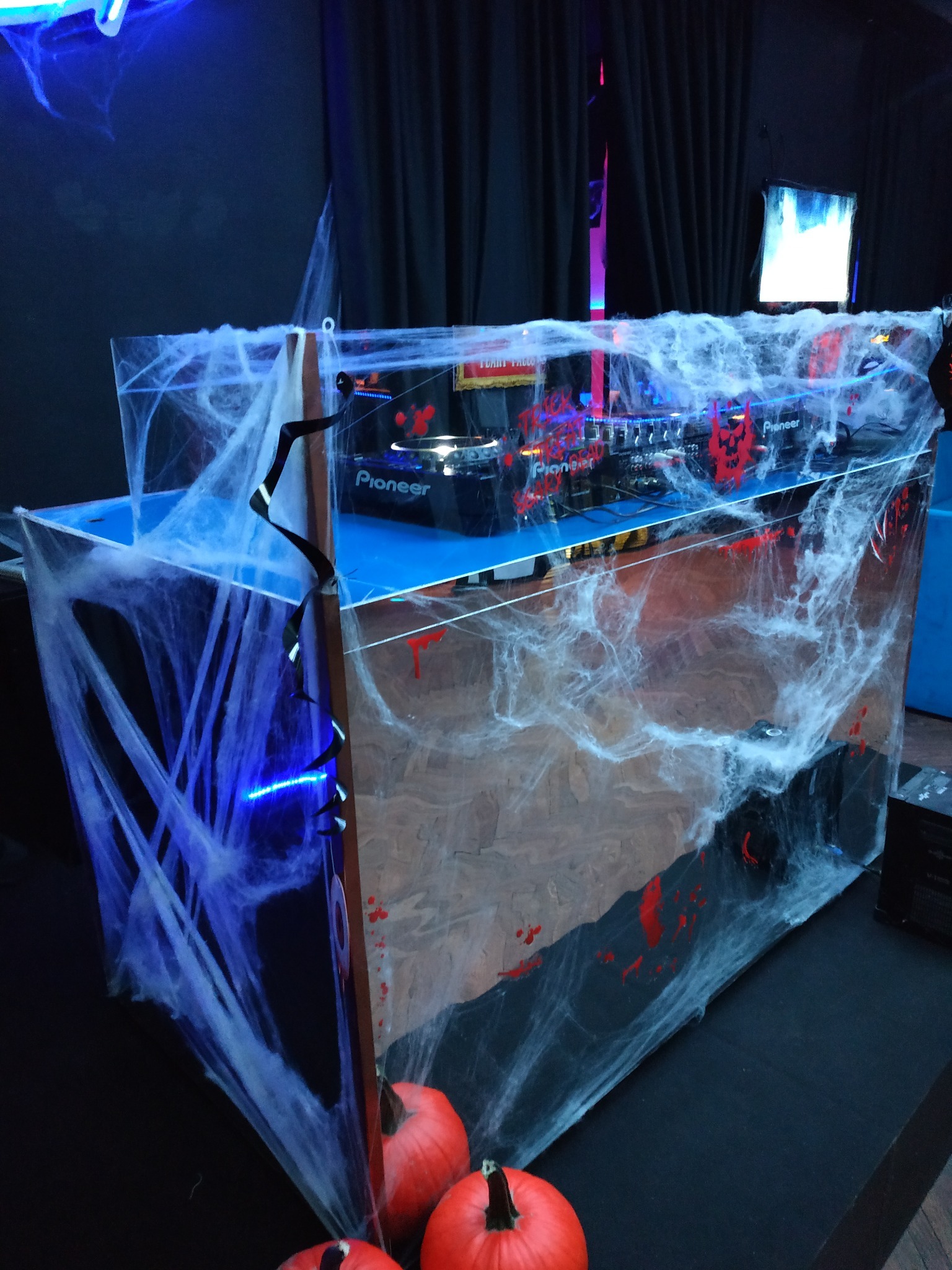 Stanowisko DJ-skie w dekoracji Halloween z pajęczynami i dyniami